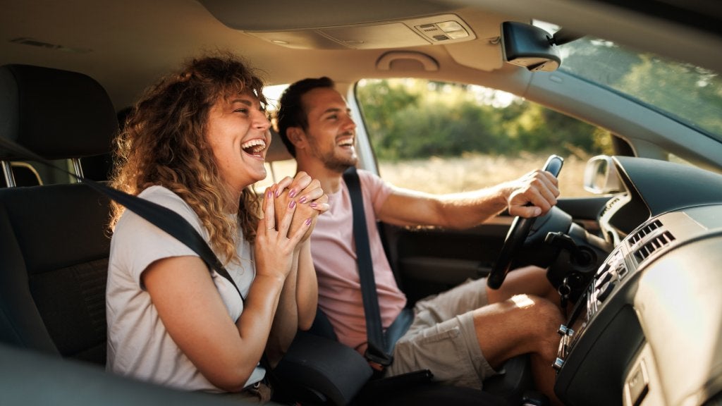 Young couple shares light-hearted moments and laughter during their adventurous car journey
