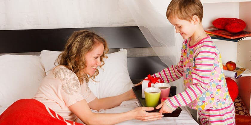 child bringing mother breakfast in bed 