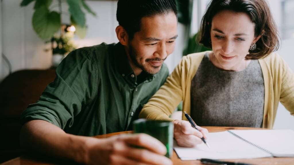 Husband and wife sit together and plan their budget.