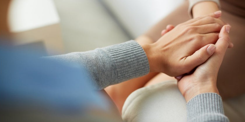two pairs of hands comforting each other 