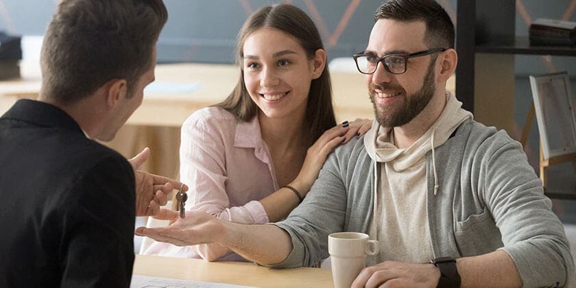young couple getting keys to new home