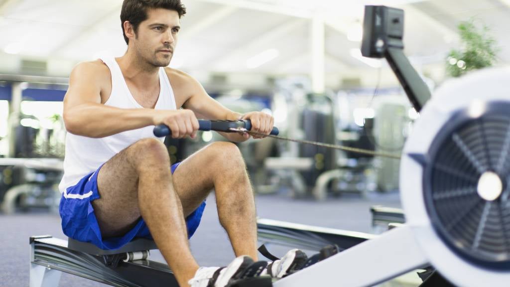 Man in blue shorts on exercise rowing machine