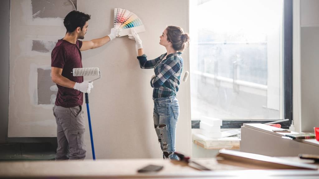 Couple renovating home and picking paint colours from a swatch.