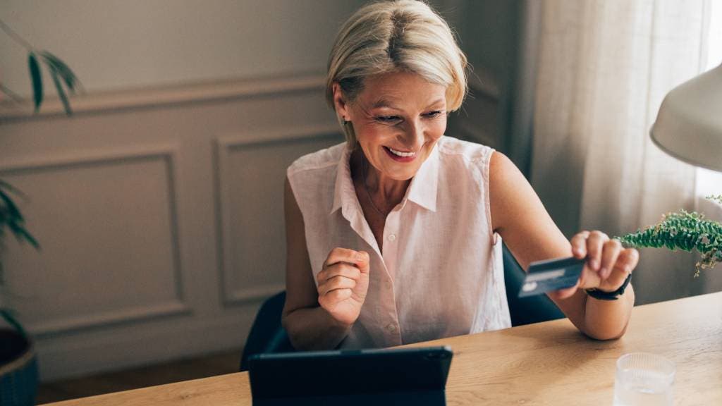 Senior woman shops online using smartphone
