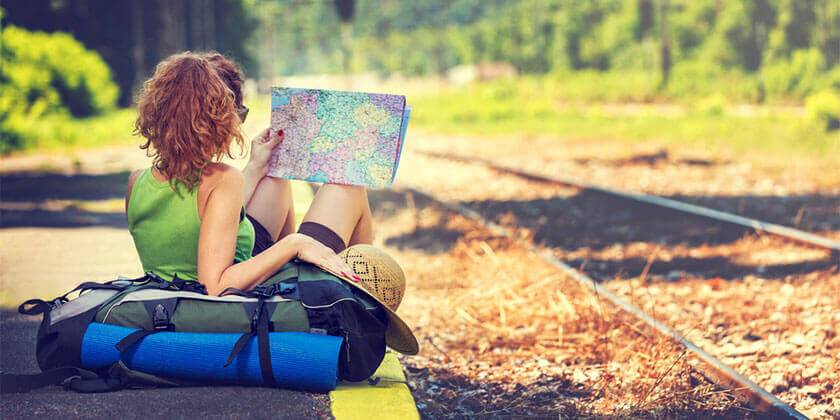travelling woman sitting at train tracks