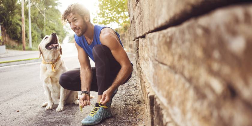 young man jogging with dog