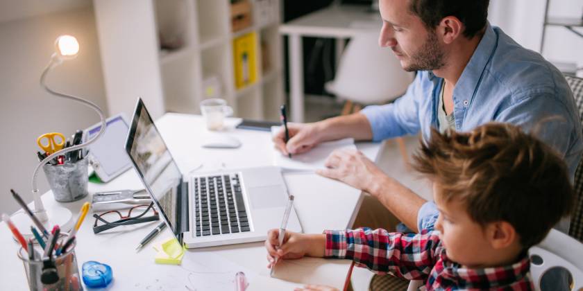 father working from home while caring for son