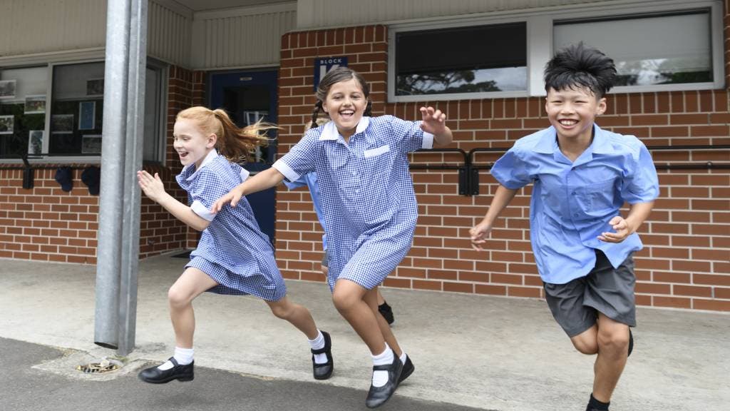 Australian boys and girls running in school uniforms