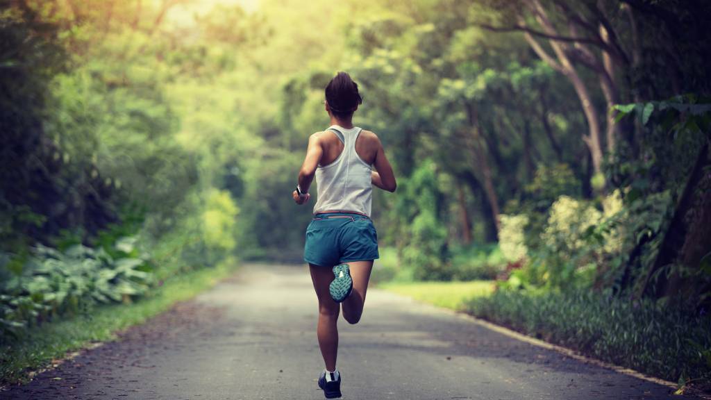 woman running along scenic road
