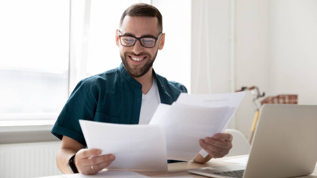 happy businessman holding and reading documents with good news