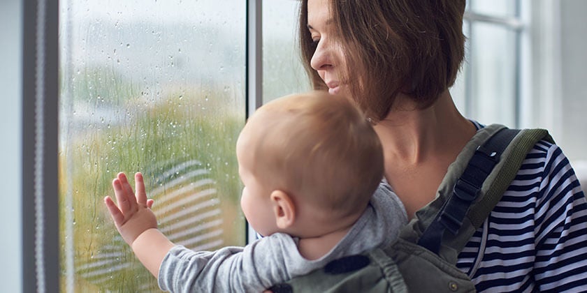 woman with baby looking out window