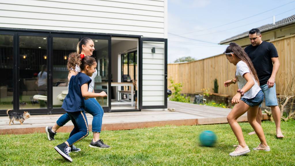 Family exercises in the back yard with ball games.