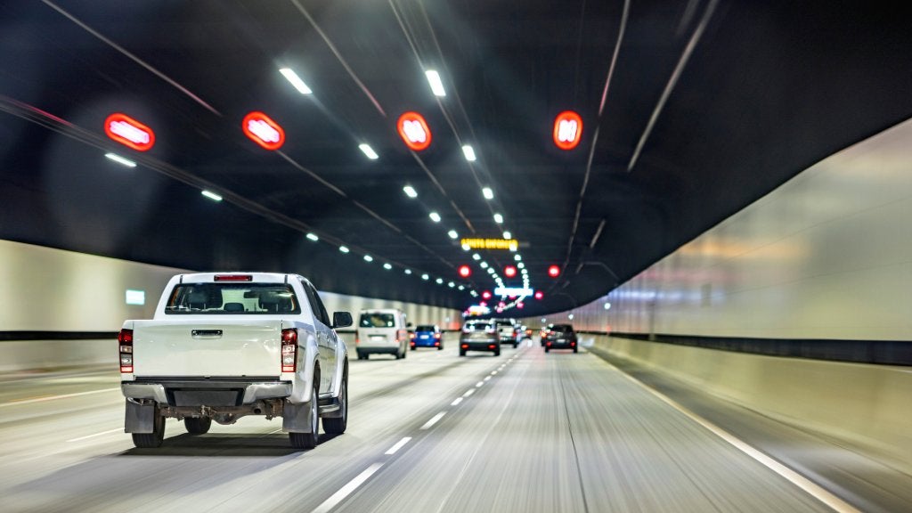 Cars driving through a brightly lit tunnel in Australia, symbolising daily commuting and urban transport