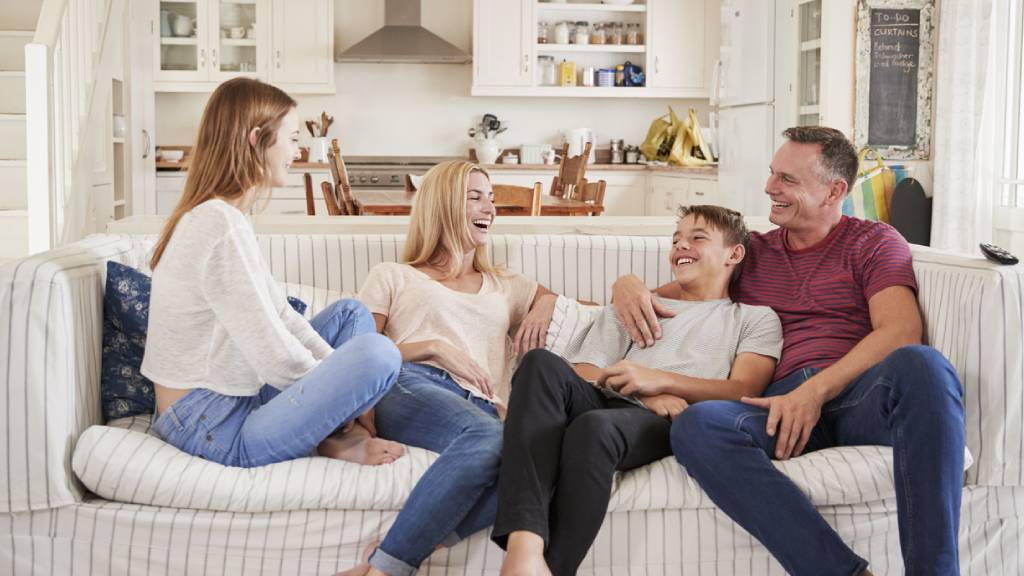 family with teenage children sitting on couch 
