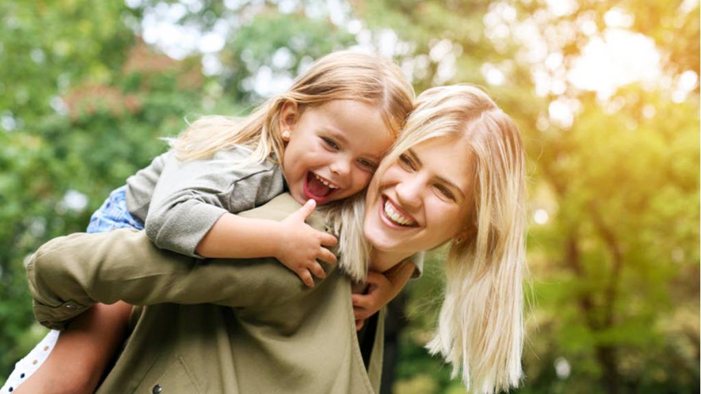 young mother playing with daughter outdoors
