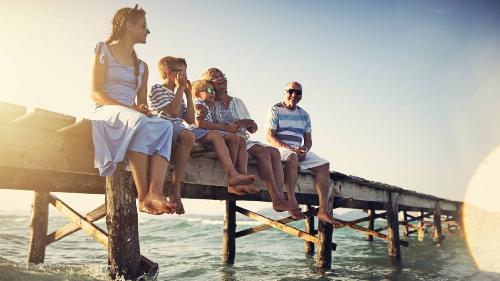 Happy family with children sitting on pier