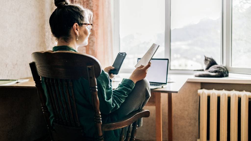 Woman working from home with cat and laptop