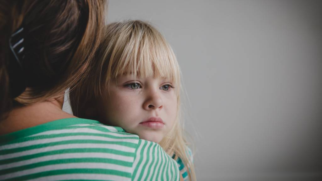 Small girl in mother's arms looking concerned