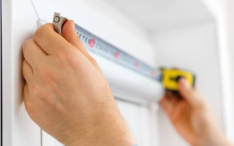 Measuring a door frame with measuring tape 