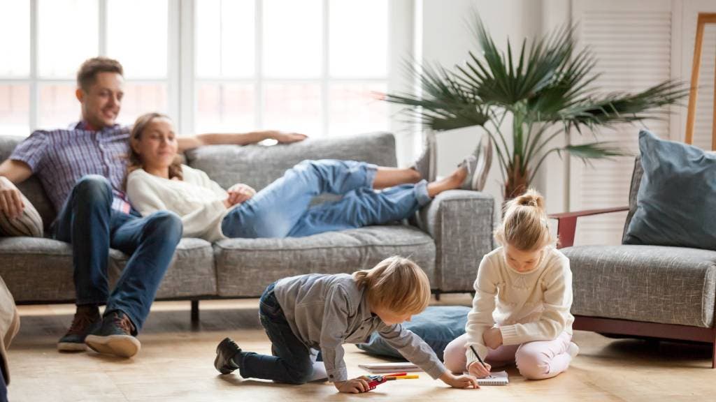Parents relaxing at home while their children play