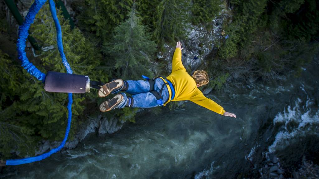 A man bungy jumping into a valley