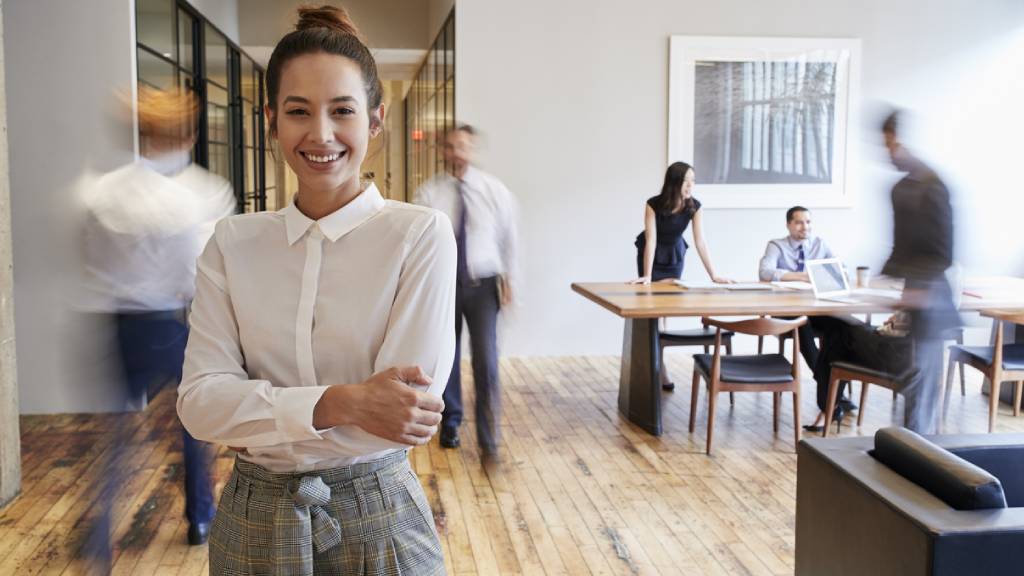 Young woman in office gear being active at work 