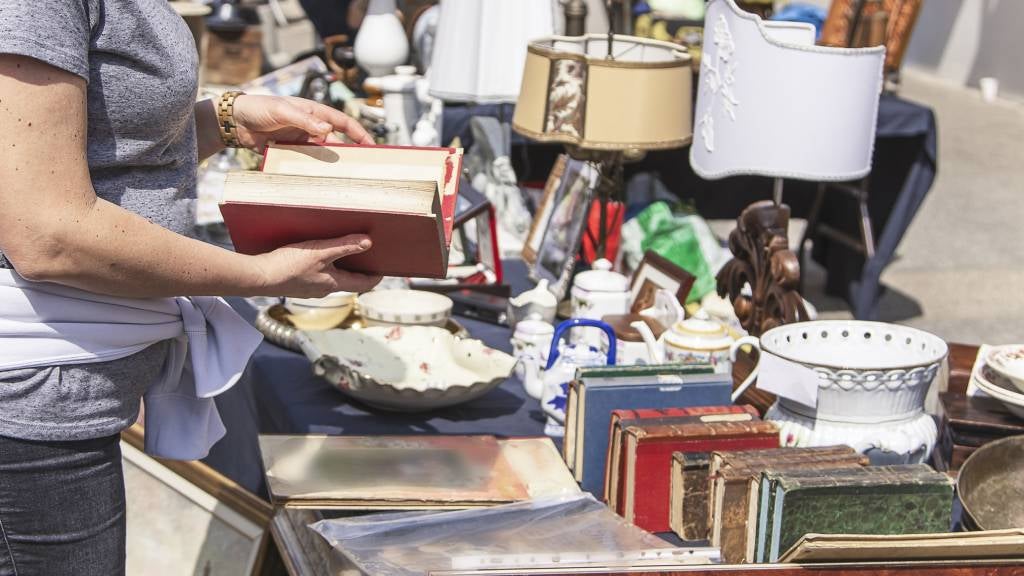 Woman rummages through items at a jumble sale.