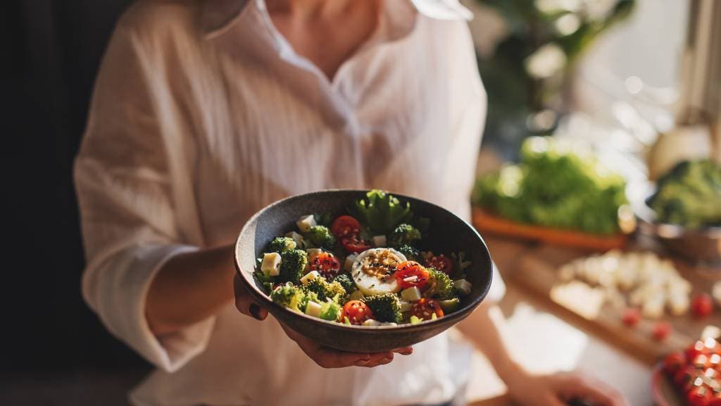 A woman hold a healthy salad bowl