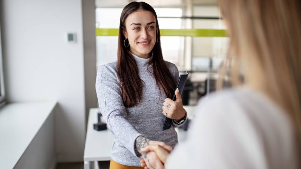 Woman shaking hands with interviewer.