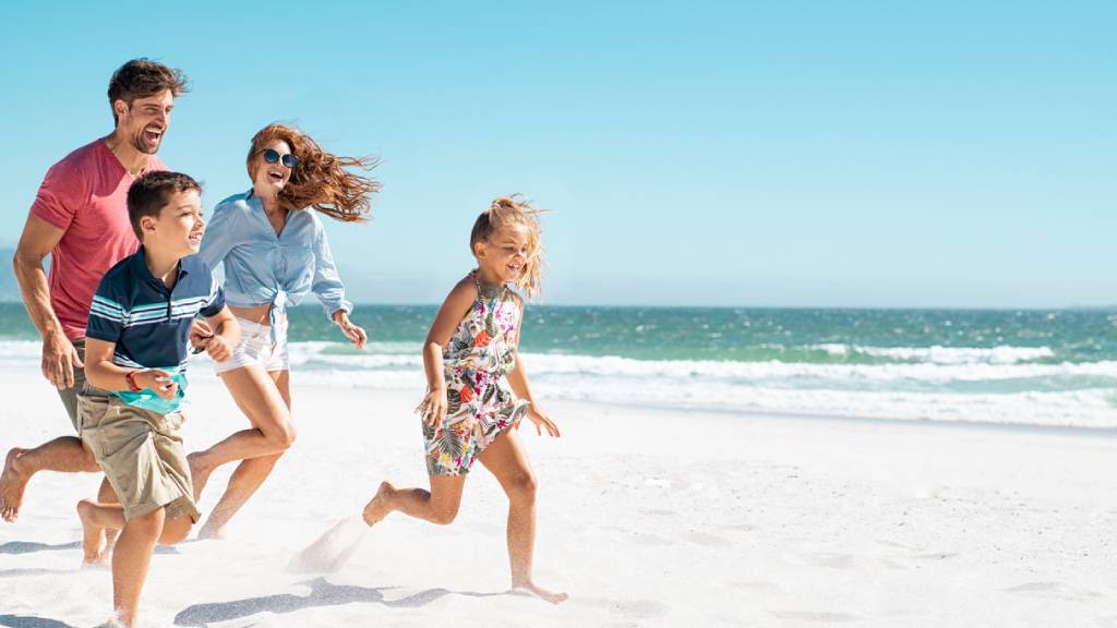 parents enjoying time with children on beach 