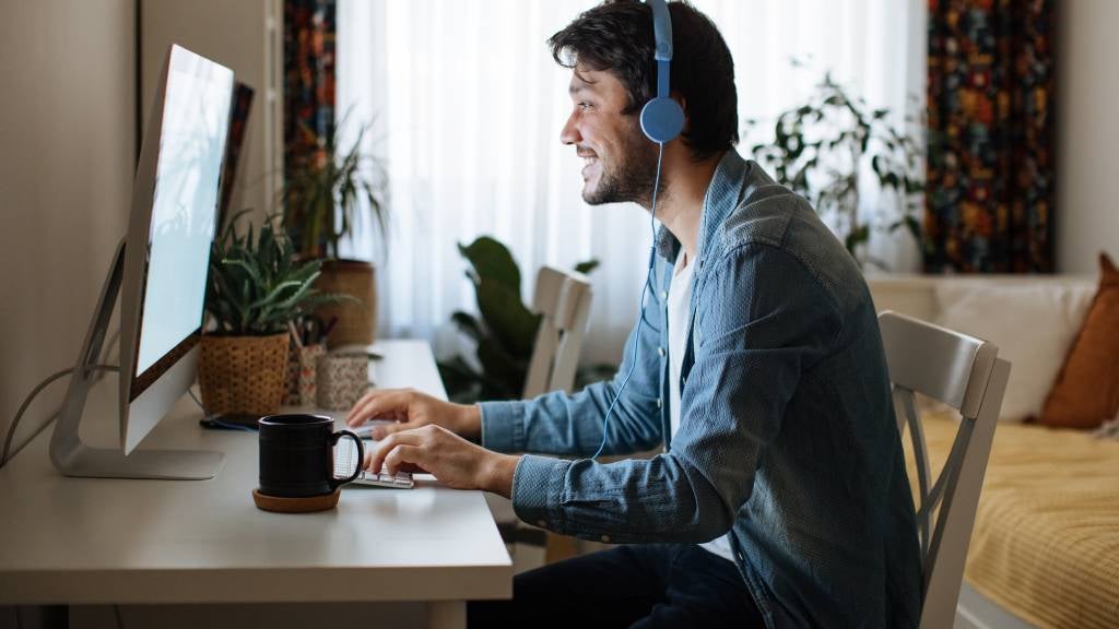 Young man attends online lecture on a Zoom call. 