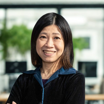 WOMEN SMILING AT CAMERA WITH DARK BLUE JACKET WITH LIGHT BLUE TRIM ON COLLAR