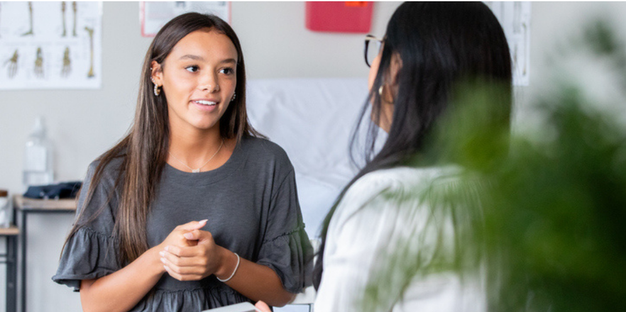The teenage girl describes her symptoms as the nurse practitioner listens closely.