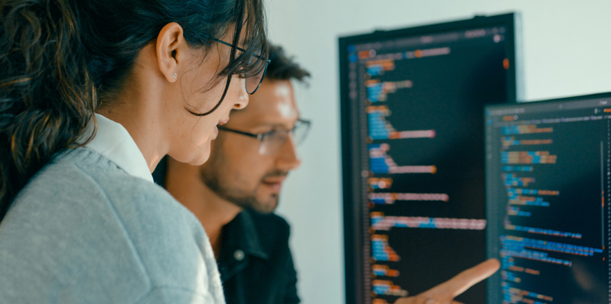 Woman and man working at screens together.