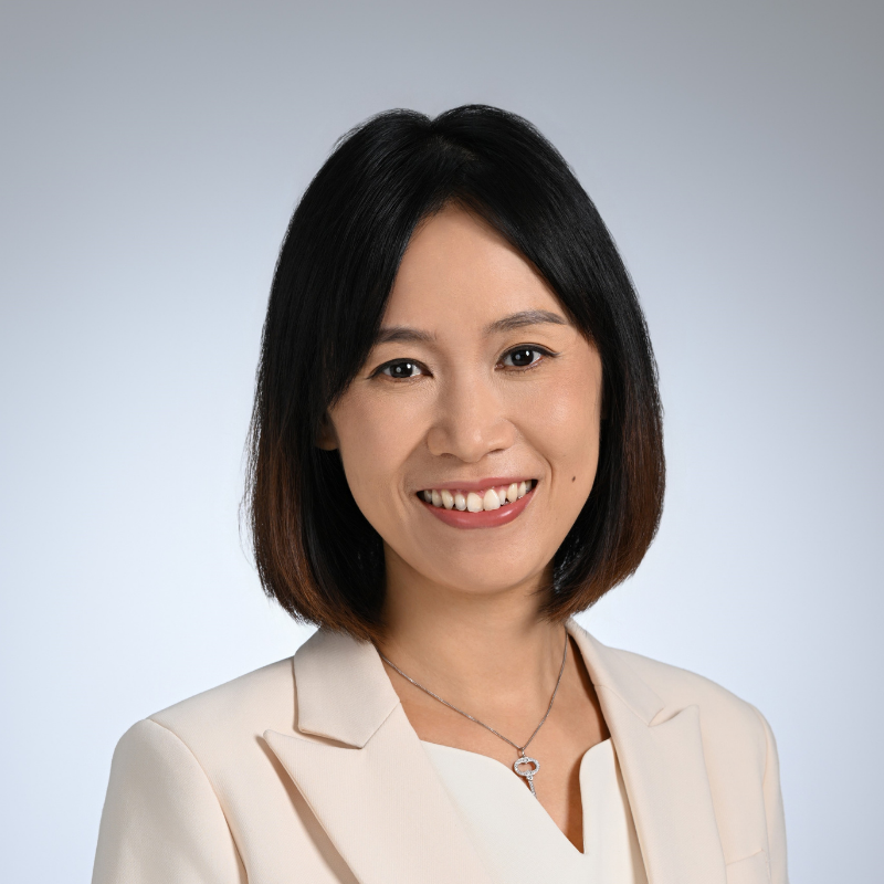 Women with black hair smiling at camera with cream dress and jacket