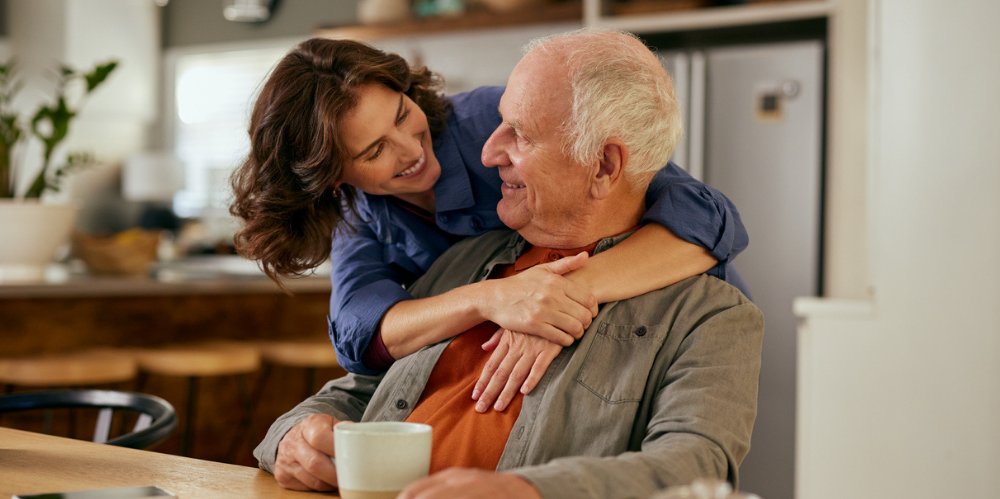 Adult daughter hugging father.