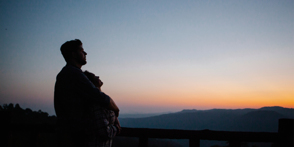 A couple looking at the setting sun.