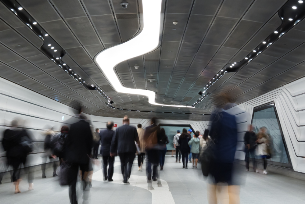 People walking in business attire through a tunnel.