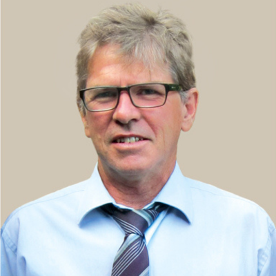 Business man with blue shirt and stripped tie smiling at camera