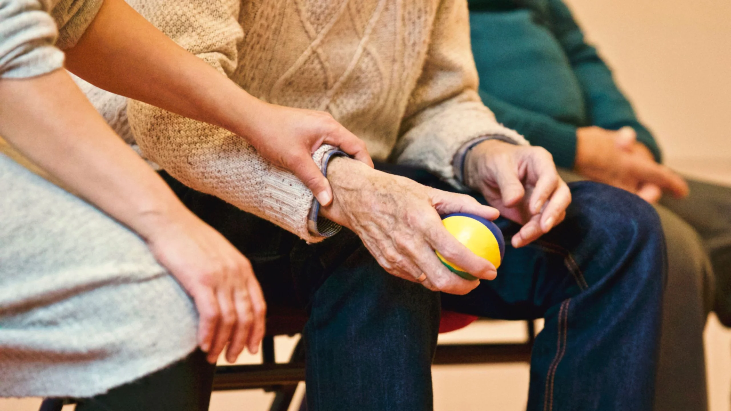 Close up of female placing hand on elderly man's arm. 
