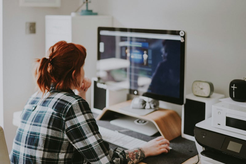 Woman sitting in front of computer looking at graphs and data