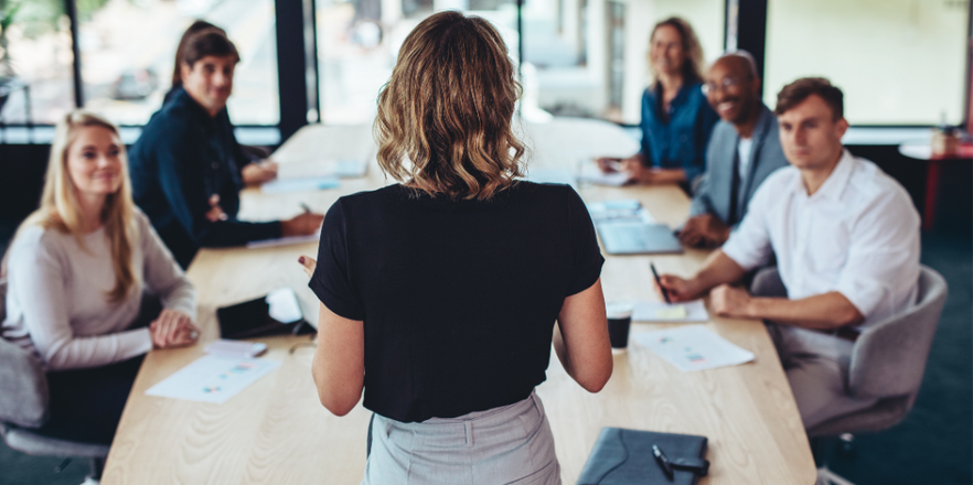 Rear view of a businesswoman addressing a meeting in office
