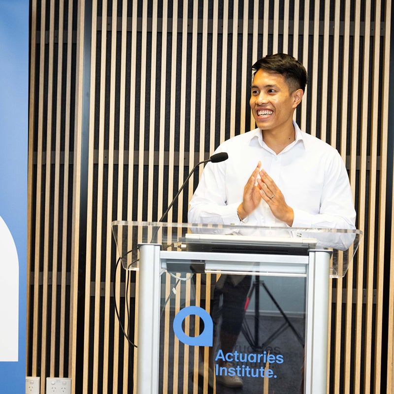 Man standing at a lectern at an Actuaries Institute event