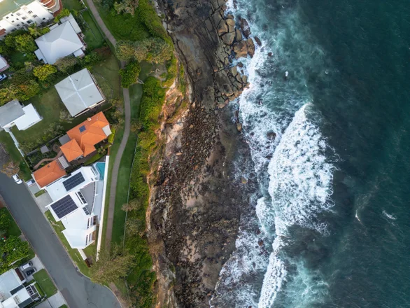 Top down view of luxury homes overlooking the cliff and rocky foreshore at Moffat headland, Sunshine Coast, Queensland, Australia