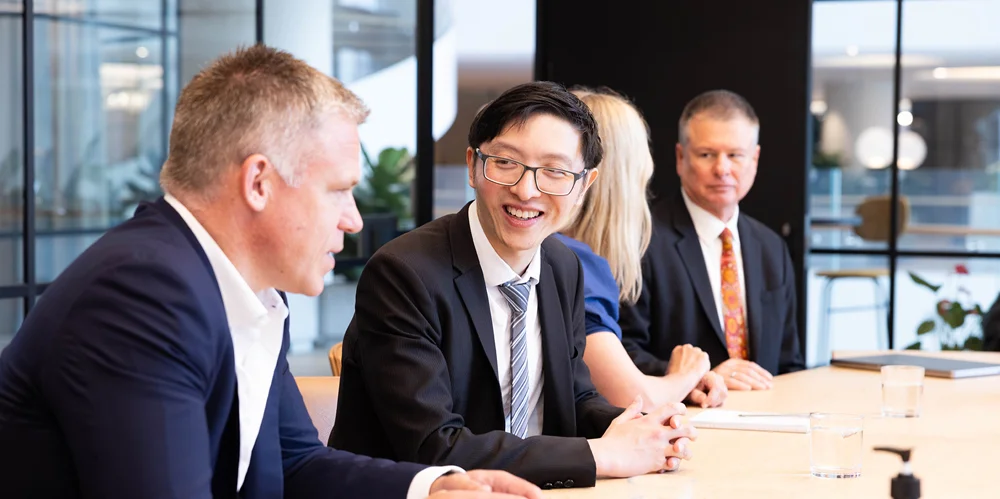 Four actuaries sitting at a boardtable having a discussion