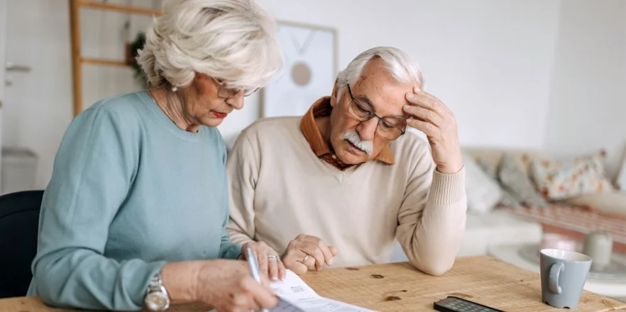 Senior couple going over bills in a domestic room