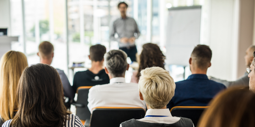 Back view of large group of business people attending a meeting.