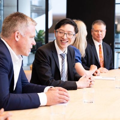 Four actuaries sitting at a boardtable having a discussion