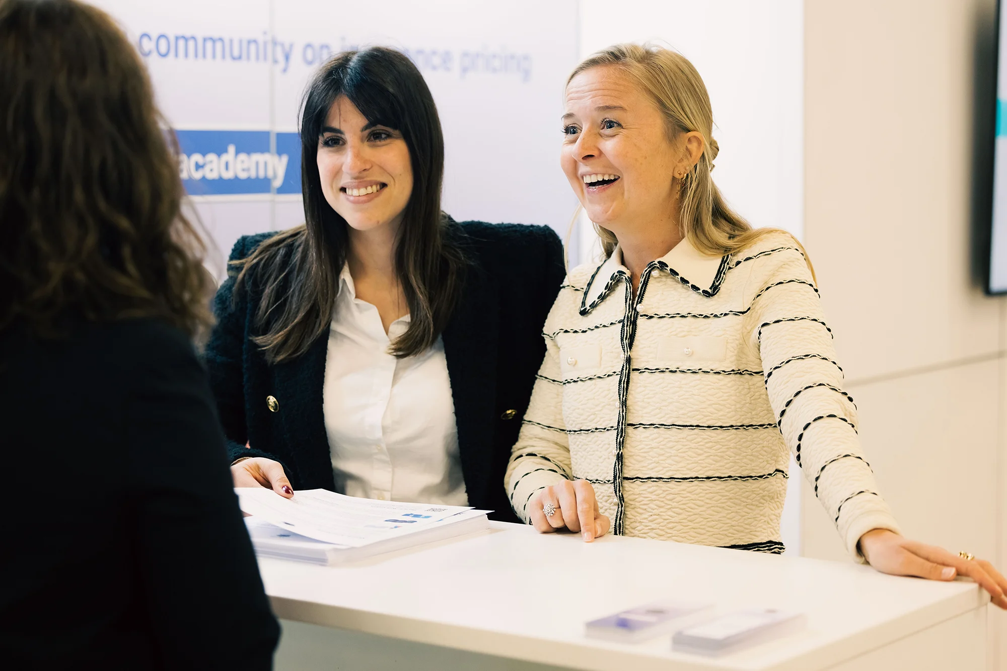 Delegate visiting two partnership program partners at a booth at conference.