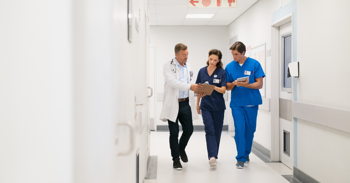 Doctor and surgeon with nurse, walking in hospital hallway